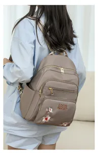 Stylish nylon backpack for women with chic floral embroidery and gold tone hardware.