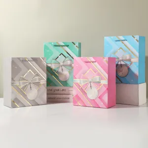 Decorative paper gift bags with elegant bows and geometric patterns for festive party packaging.