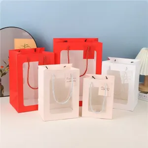Cadeautassen met doorzichtig venster in detail, gekleurde papieren tassen voor bloemen.