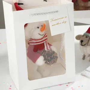 Borsa regalo in carta bianca con finestra trasparente e peluche di pupazzo di neve.