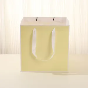 Sac cadeau papier carré vue détaillée, design jaune clair rubans blancs pour fleurs et gâteaux.
