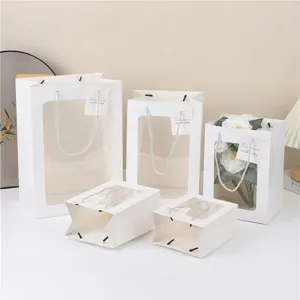 Witte papieren geschenktassen met doorzichtig venster, elegante draagtassen voor bloemboeketten.