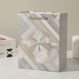 Elegant bow gift bag with white cardboard material, luxury geometric pattern for parties and gifts.