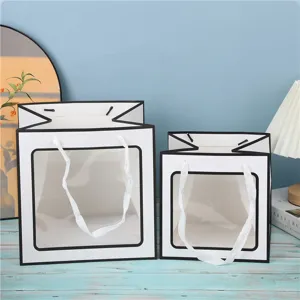 Sac cadeau carré avec fenêtre transparente en détail, emballage blanc avec bordure noire.