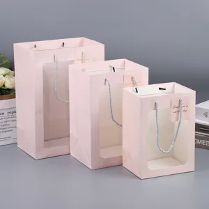 Pink paper gift bags with transparent window, cute tote bags for flower packaging and party presents.