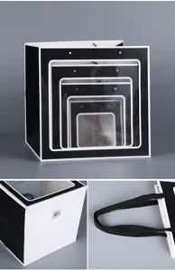 Vista detallada de la bolsa de regalo negra con ventana transparente y etiqueta en el fondo.