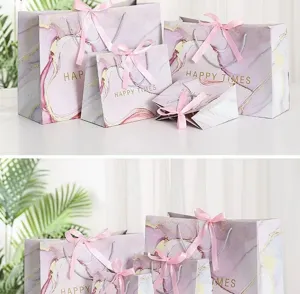 Pink marble pattern gift paper bags with cute pink ribbon bows, perfect for party favors and gifts.