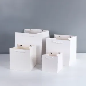 Detailed view of white square paper gift bags with wide bottom, thick paper shopping bags for baking.