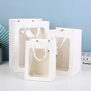 Gedetailleerd overzicht van witte papieren cadeauzakjes met doorzichtig venster voor bloemen en gifts.