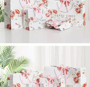 Elegant rose print gift bags with pink bows and handles, perfect for party and holiday favors.