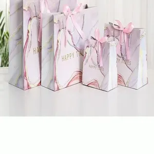 Elegant marble gift bags with pink ribbon bows, perfect for party favors and luxury retail packaging.
