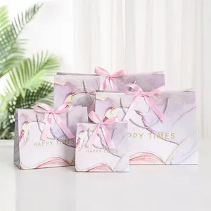 Elegant purple marble gift bags with pink ribbon bows for wedding favors and parties.