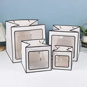 Vue détaillée de sacs cadeaux blancs avec fenêtre transparente de différentes tailles.
