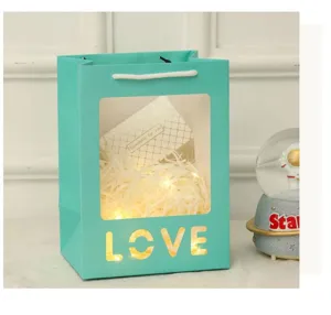 Detail van de turquoise cadeautas met Love uitsparing, venster en mooie lichtjes.