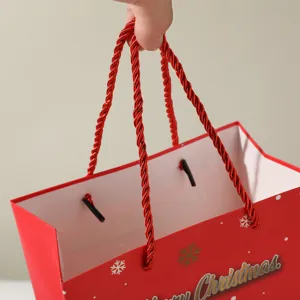 Nahaufnahme Detailansicht der roten Weihnachtstüte aus Papier mit stabilen gedrehten Griffen.