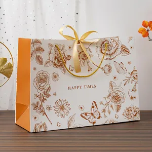 Sac cadeau en papier à fleurs dorées avec ruban pour emballage de fête élégant