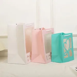Cadeautassen van papier met doorzichtig venster, kleurrijke draagtassen voor bloemen en feest.