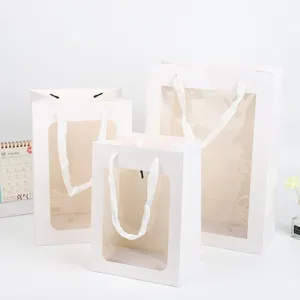 Witte papieren cadeautasjes met doorzichtig venster, ideaal voor bloemenverpackung en verjaardagen.