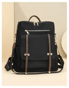 Vue détaillée de sac à dos noir en nylon, sac de voyage pour navette avec brides marron.