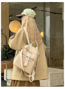 Casual canvas backpack detail view showcasing chic white straps and front pocket design.