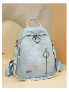 Detail view of light blue casual backpack showing ring zipper pulls and patterned shoulder straps.