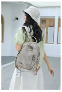 Casual soft leather travel backpack detail showcasing wide strap and metal rings.