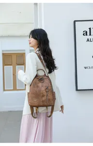 Detailed view of women retro soft leather backpack with stylish rings and straps.