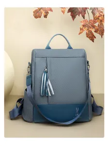Zaino donna elegante grigio-blu antifurto con nappa decorativa per lavoro e tempo libero.