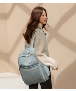 Detailed view of a light blue nylon backpack worn by a model, spacious and stylish for daily use.