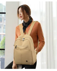 Casual khaki nylon backpack detail view, featuring spacious compartment and handy pockets.