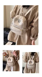 Detailed view of the stylish beige leather mini backpack featuring multiple front zippers.