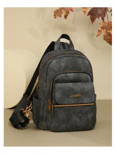 Close-up detail of the stylish dark grey multi-purpose leather backpack with zippers.