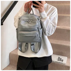 Grey leather mini backpack with multi-zipper pockets, stylish and spacious for daily use.