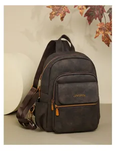 Detailed close-up of dark brown vintage PU leather women backpack with front pocket zippers.