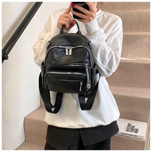 Detail view of a stylish black leather backpack showcasing multiple functional zippers and straps.