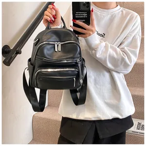 Detailed view of black PU leather women backpack, showcasing multi-pocket design and quality zippers.