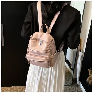 Close-up of pink leather women's backpack showing soft material and metal zippers.