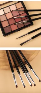 Gros plan de pinceaux de maquillage pour les yeux professionnels et palette colorée.