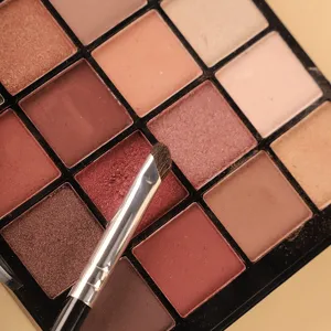 Brocha de maquillaje en ángulo profesional con paleta de sombras de ojos multi color.