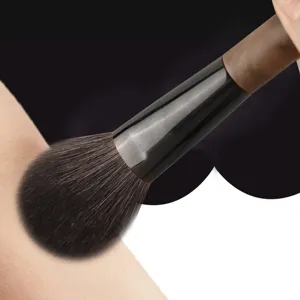 Professional makeup brush with soft bristles and walnut wood handle for flawless face powder.