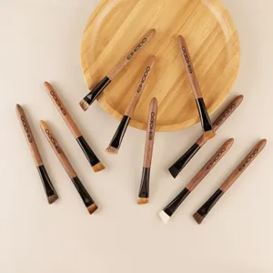Walnut handle angled eyebrow brush for precise makeup application and shaping defined brows.