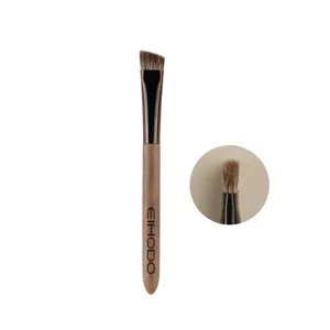 Angled eyebrow brush with wooden handle and soft bristles for precise makeup application.