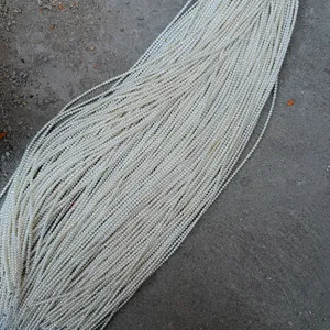 Dettaglio macro di fili di perle naturali d'acqua dolce bianche da 2-3 mm per gioielli