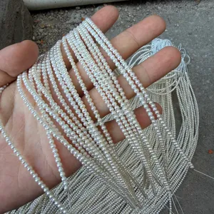 Primo piano di mini fili di perle d'acqua dolce naturali 2-3mm per la creazione fai da te