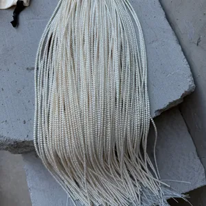 Dettaglio di perle baby naturali d'acqua dolce da 2-3mm ad alta lucentezza per gioielli fai da te.