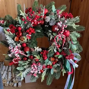 Couronne de Noël festive décorée de baies rouges, de pommes de pin et de sucres d'orge