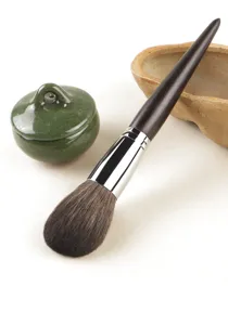 Large makeup powder brush with dark wooden handle and soft hair for facial makeup tool.