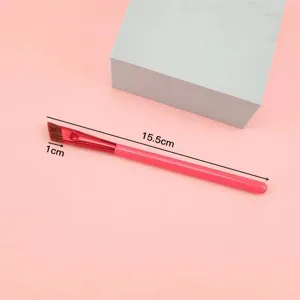 Pennello per sopracciglia angolato professionale con manico rosa per un trucco preciso.