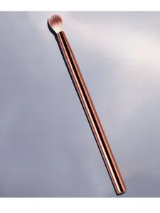 Close-up view of the tapered makeup blending brush with a sleek metallic copper handle.