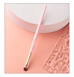 Primer plano de pincel detalle sombra de ojos rosa con cerdas suaves y diseño profesional.